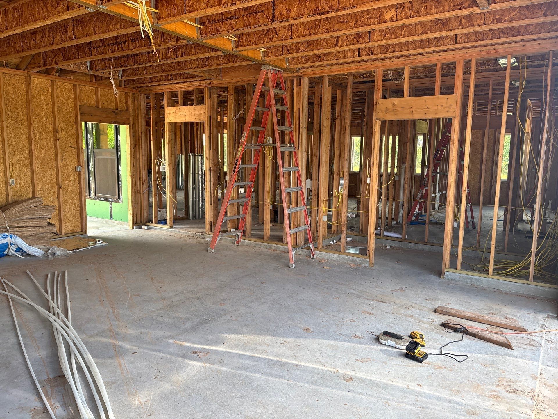 Interior of a building under construction, wooden frames with a ladder.