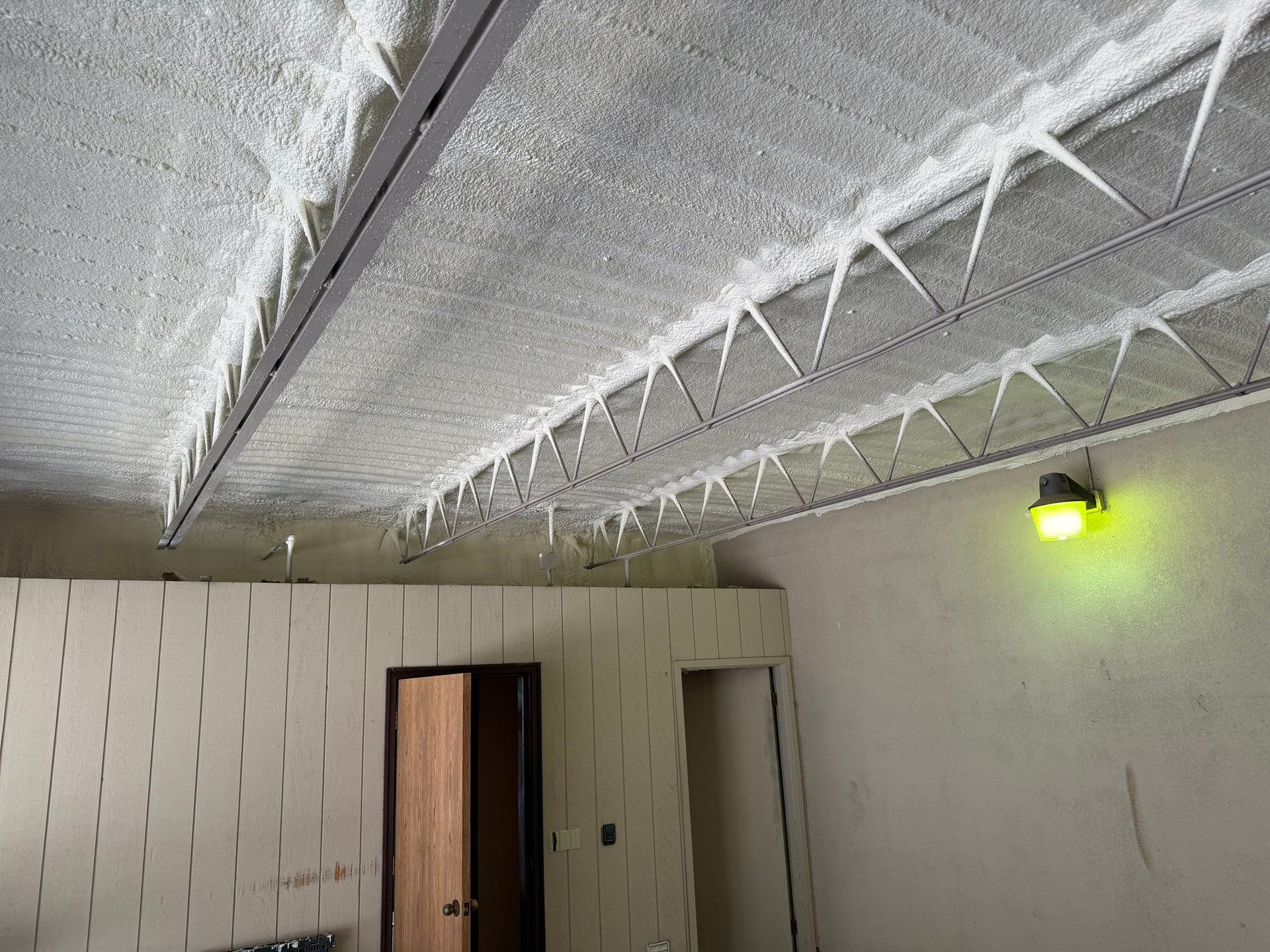 Interior view with icicles hanging from a ceiling. Walls are light-colored. A door and light fixture are visible.