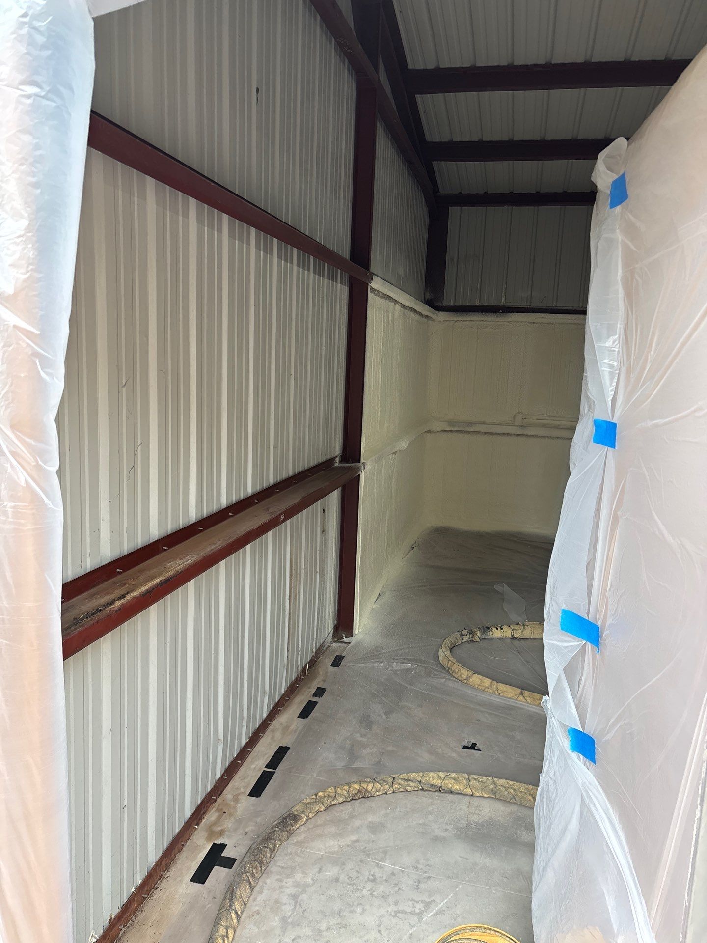Interior of a metal building with spray foam insulation on walls and ceiling.