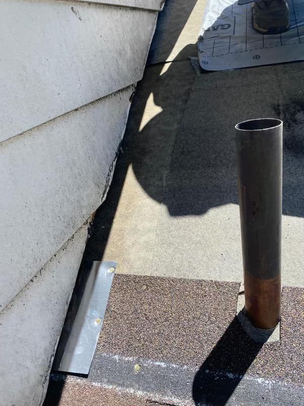 A close up of a pipe on the side of a building.