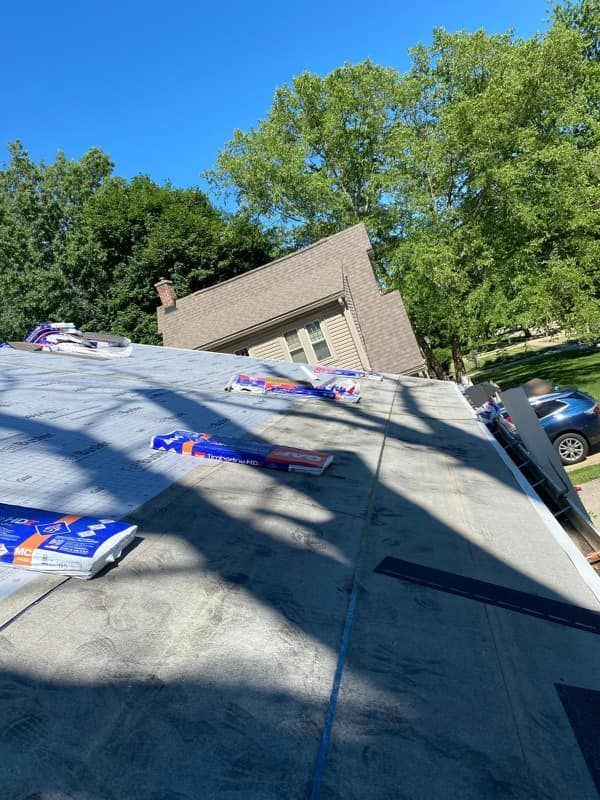 A roof with a lot of bags on it and a house in the background.