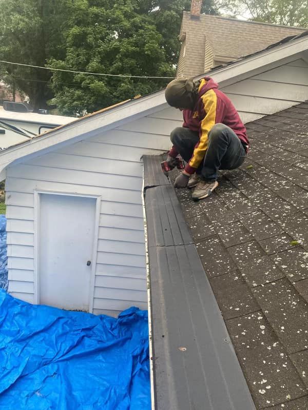 A man is working on the roof of a house.