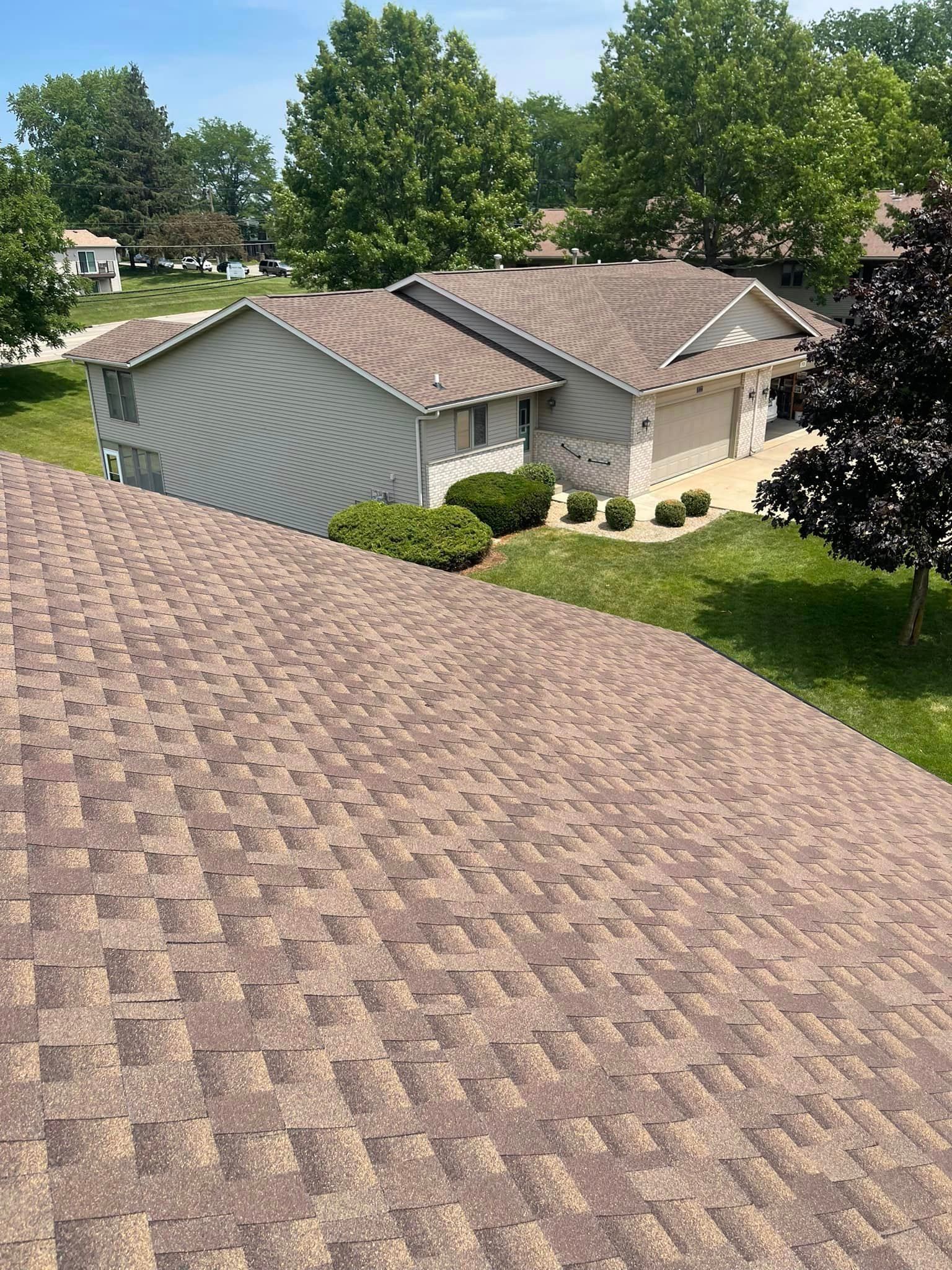A roof of a house with a lot of trees in the background.