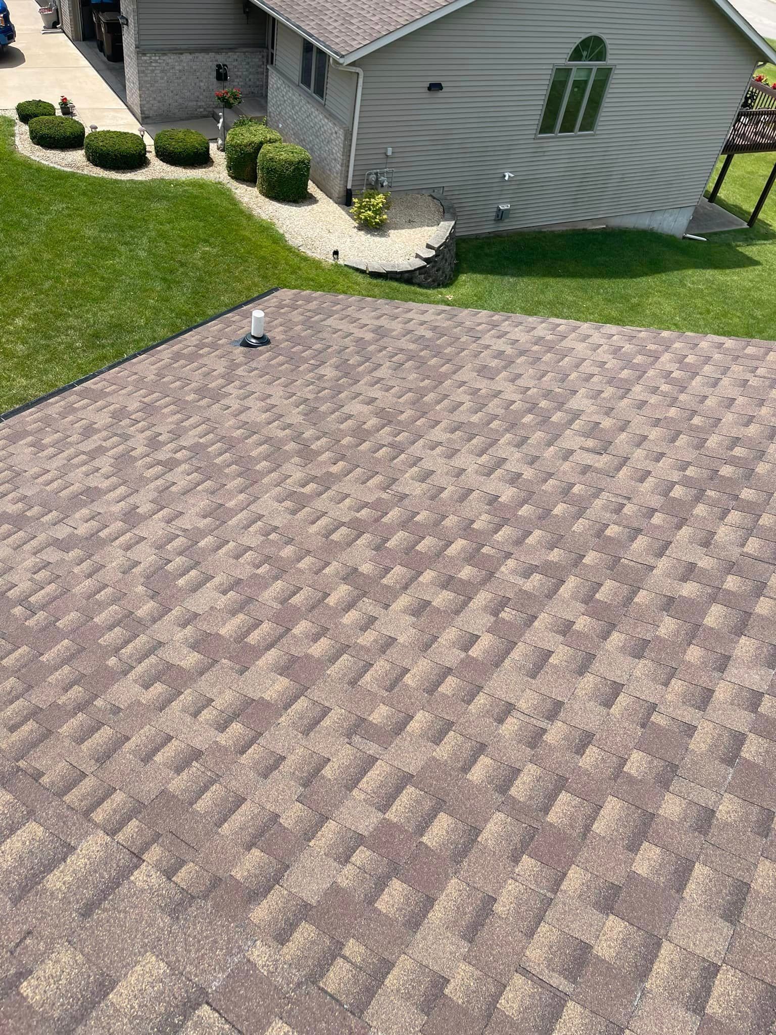 An aerial view of a house with a roof and a driveway.