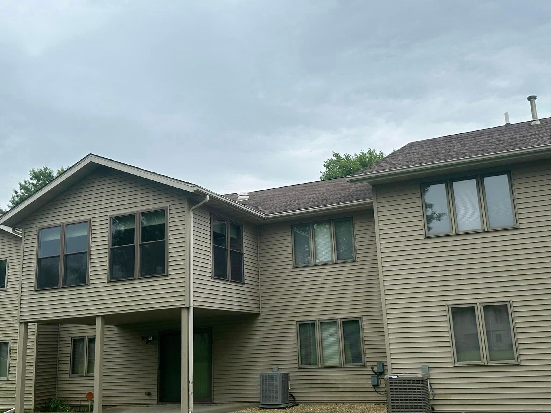 A large house with a lot of windows on a cloudy day.