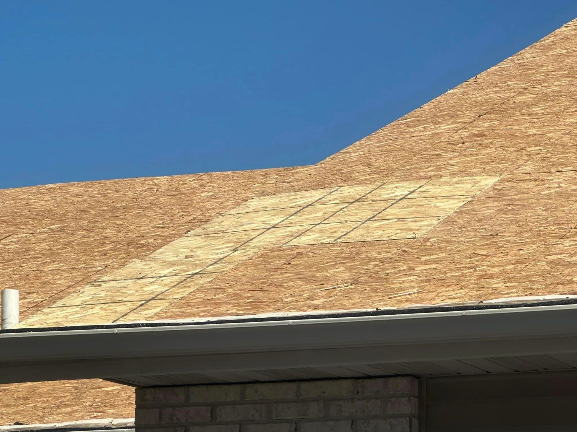 A brown roof with a blue sky in the background.