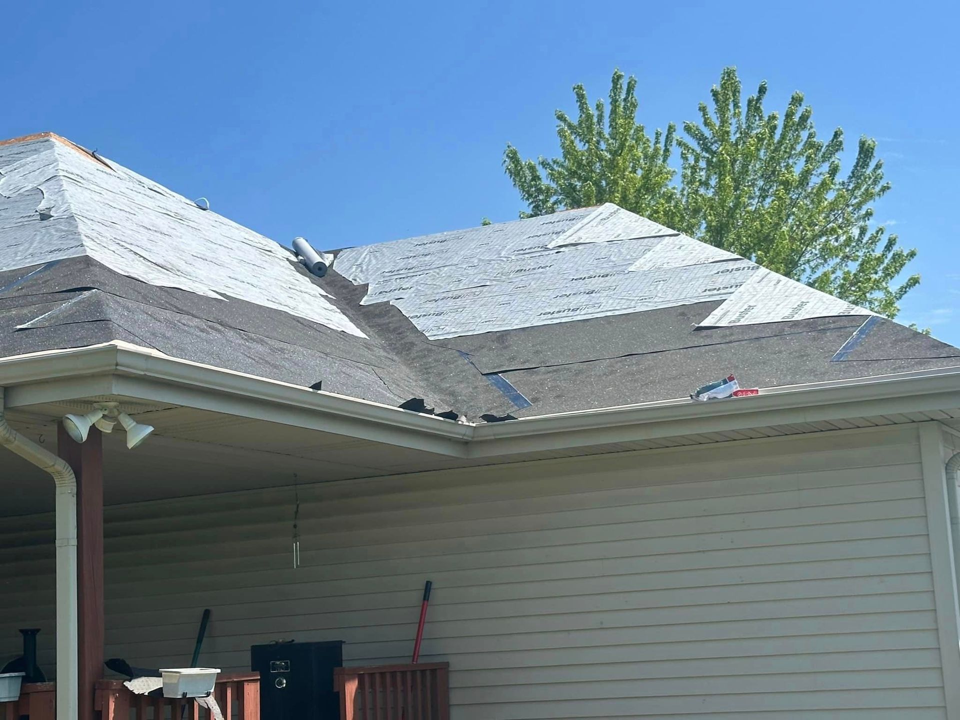 A white house with a roof that is being repaired.