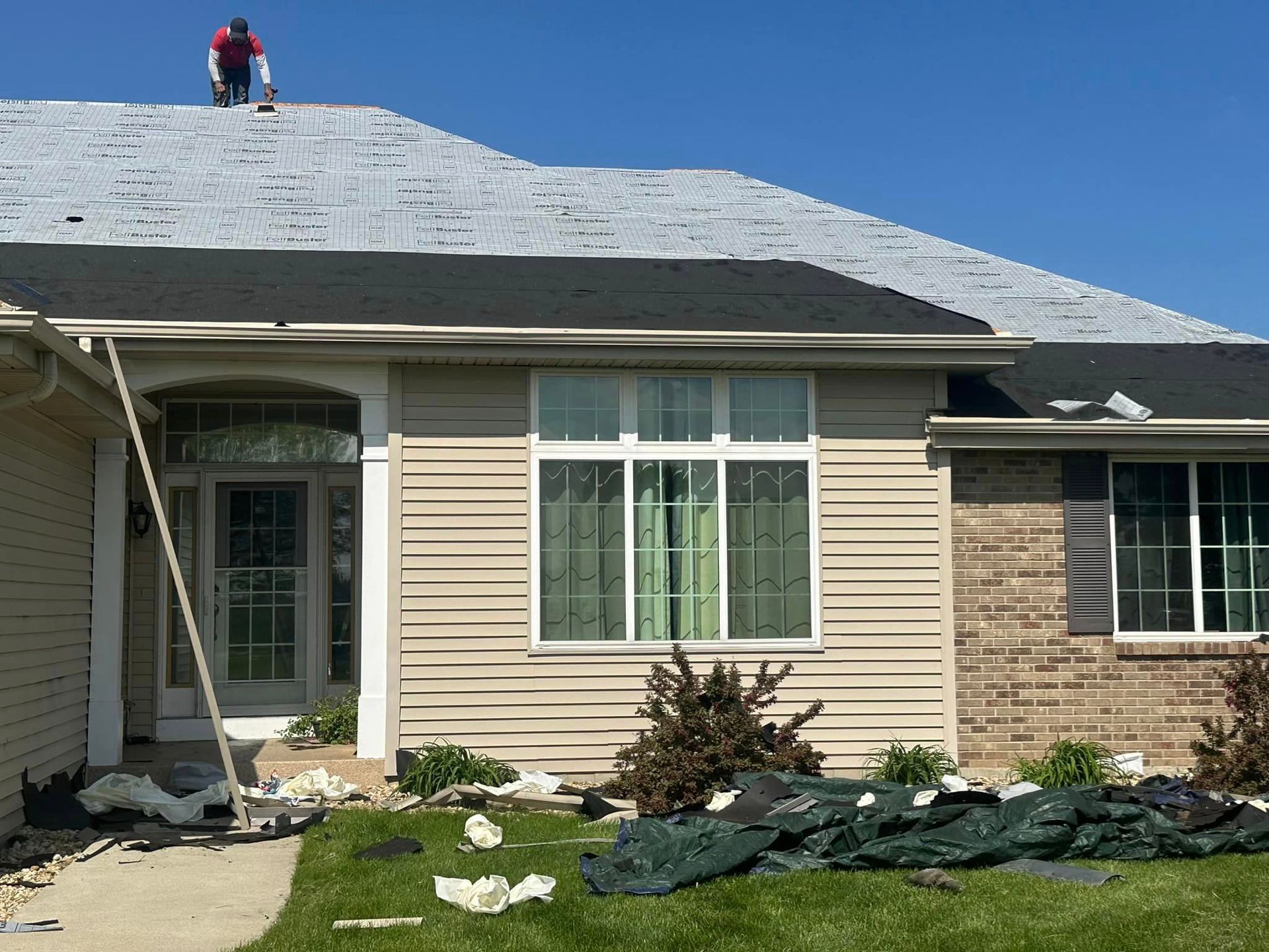 A man is working on the roof of a house.