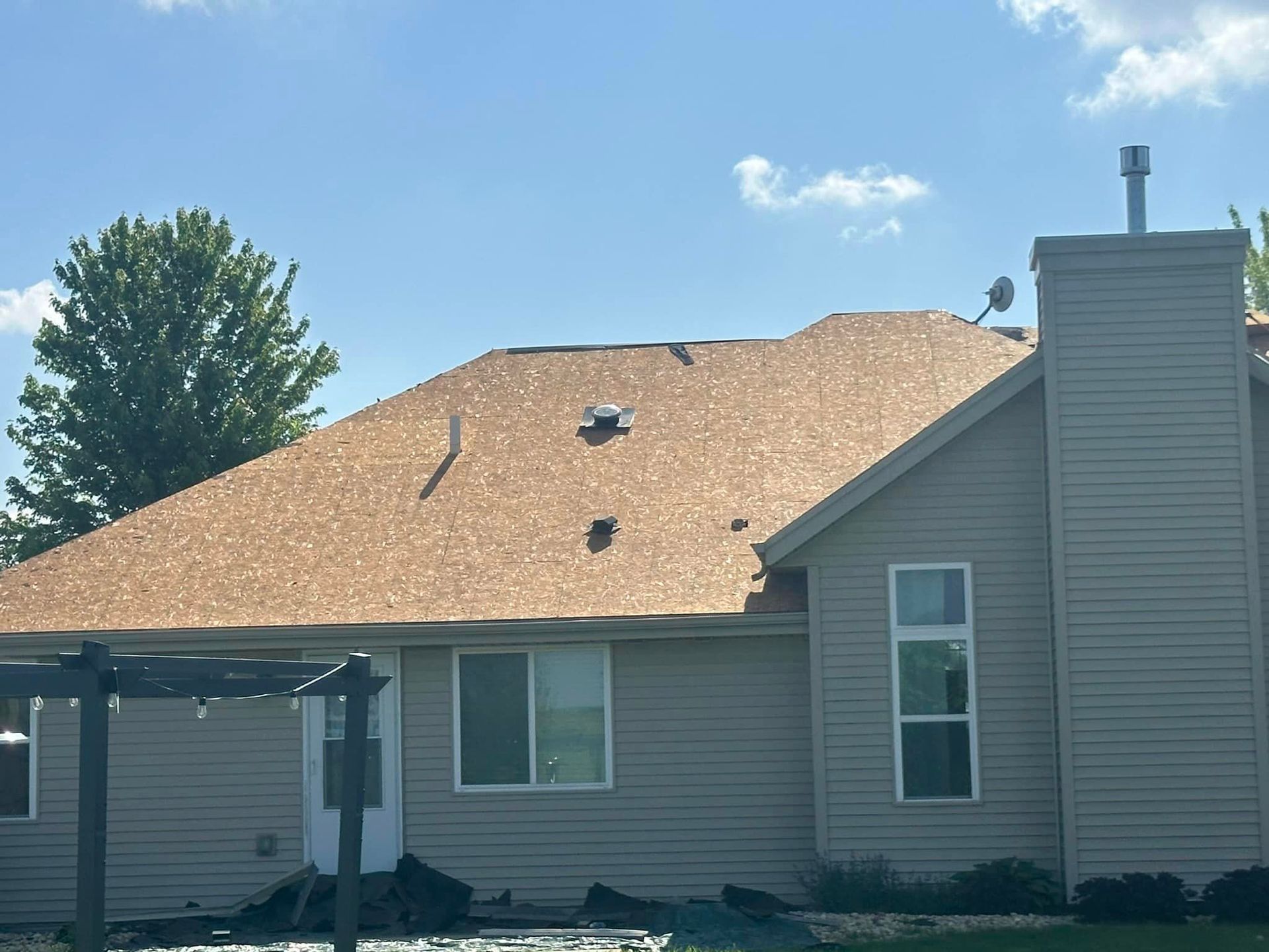 A house with a brown roof and a chimney.