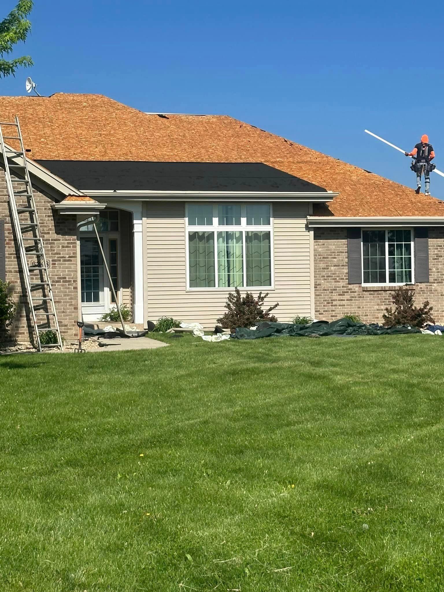 A man is standing on the roof of a house.