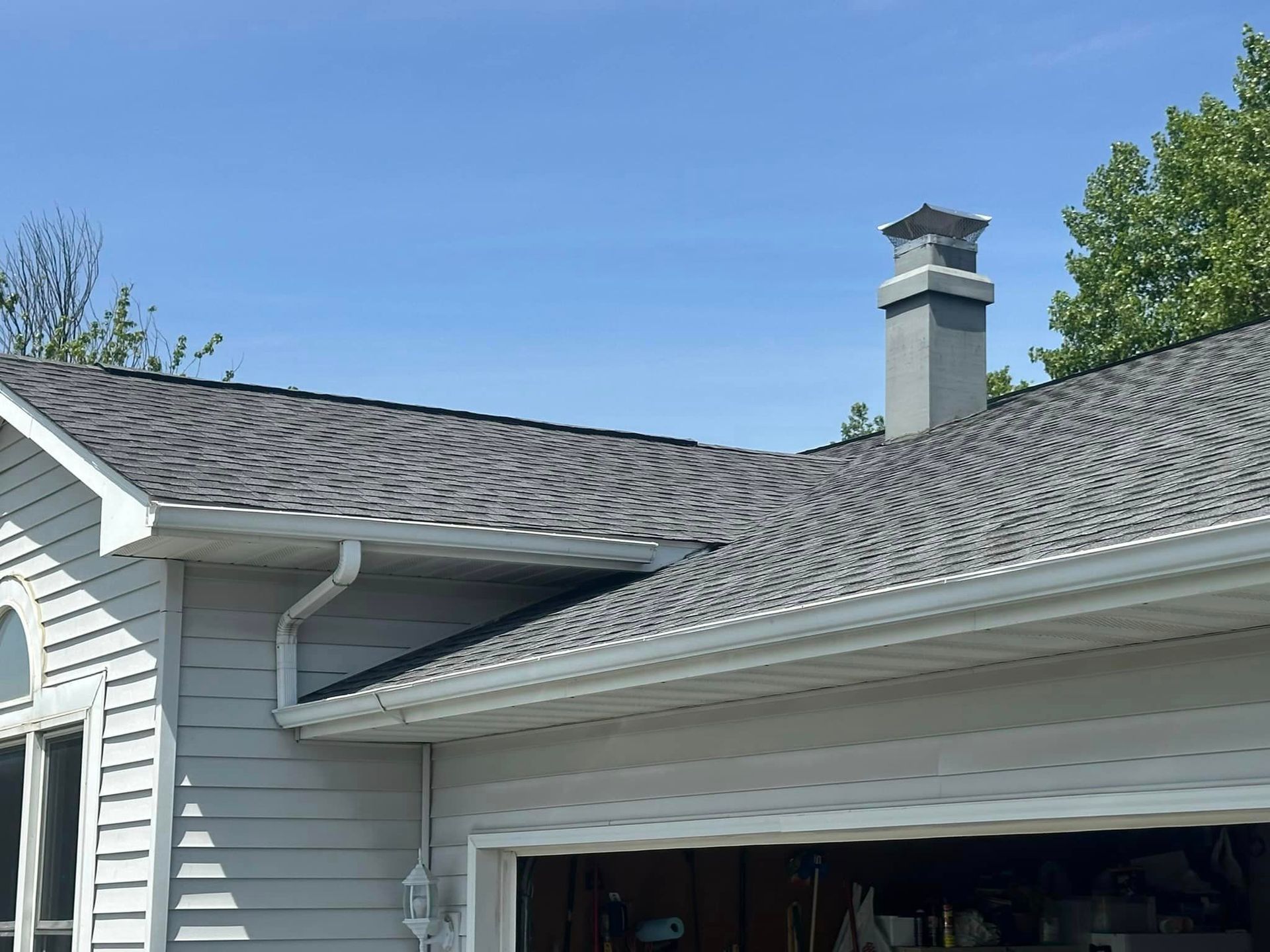 A white house with a chimney on the roof.