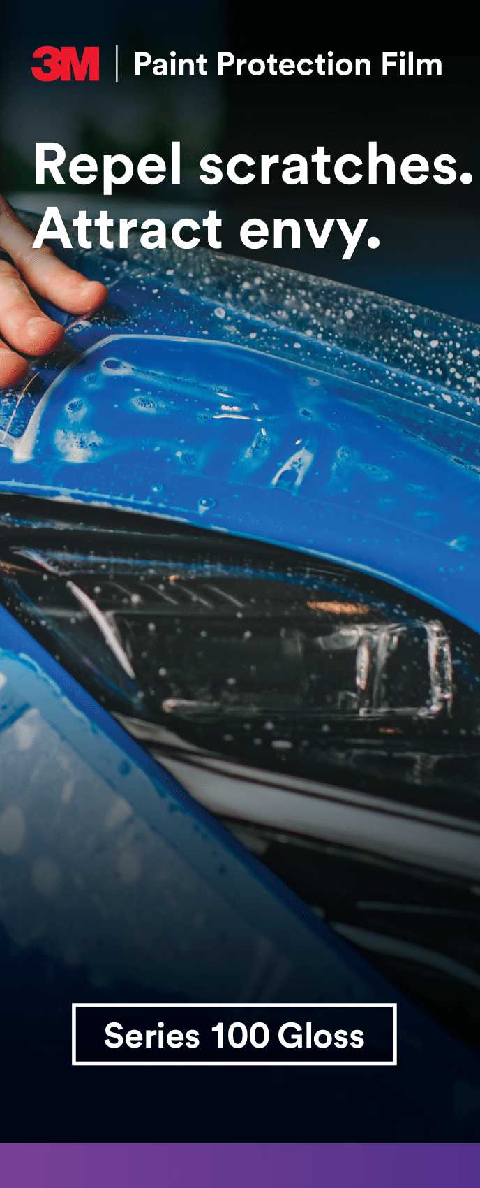 A person is applying paint protection film to a blue car.