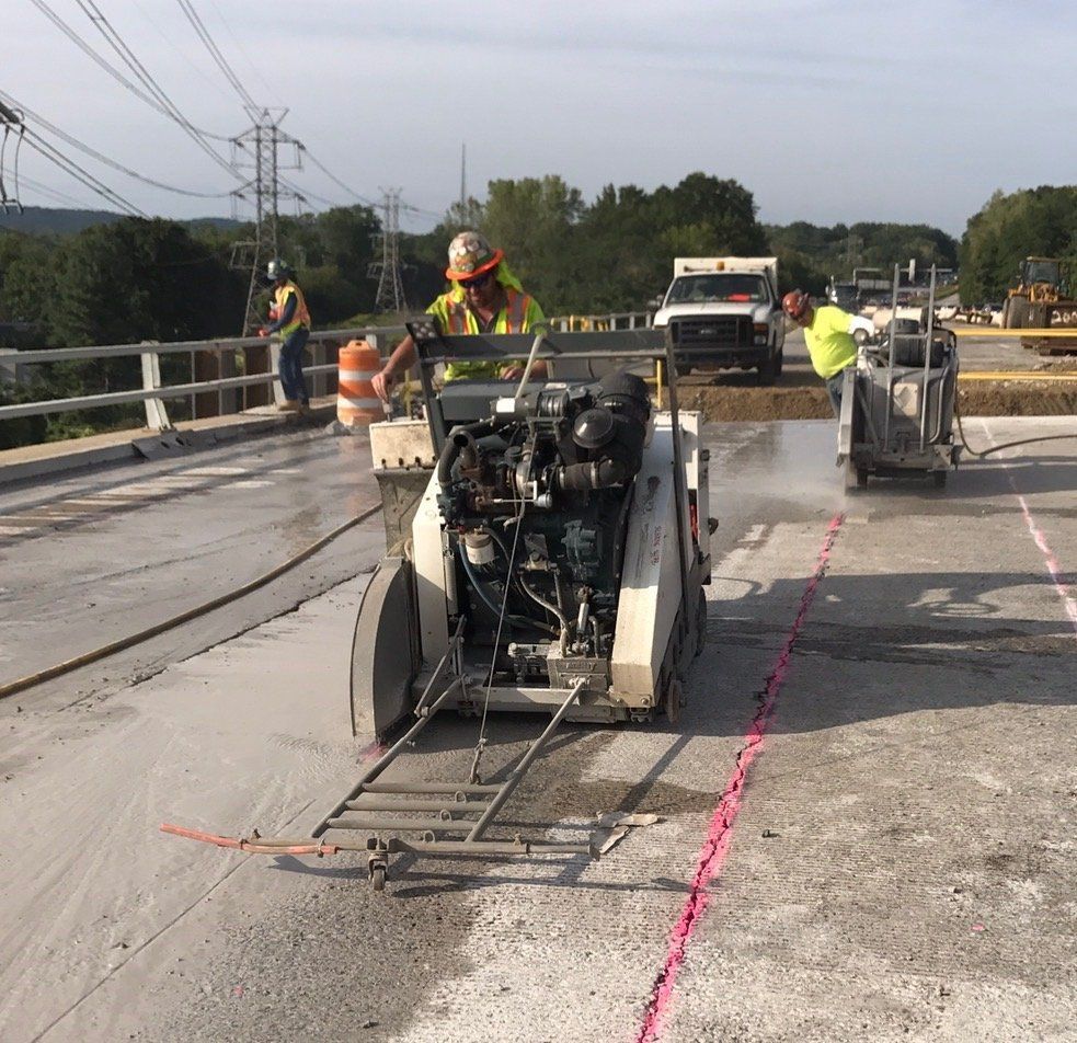 Construction workers are cutting concrete on a bridge