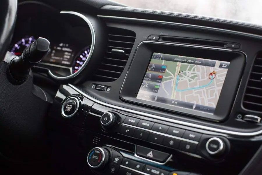 Car dashboard with GPS navigation screen and center controls, viewed from the driver’s seat