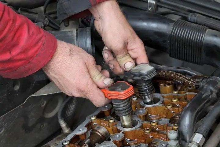 Mechanic hands installing timing chain components inside an engine