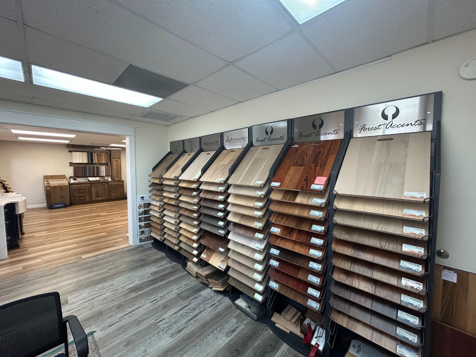 A showroom display rack holding various wood flooring samples in a brightly lit room.