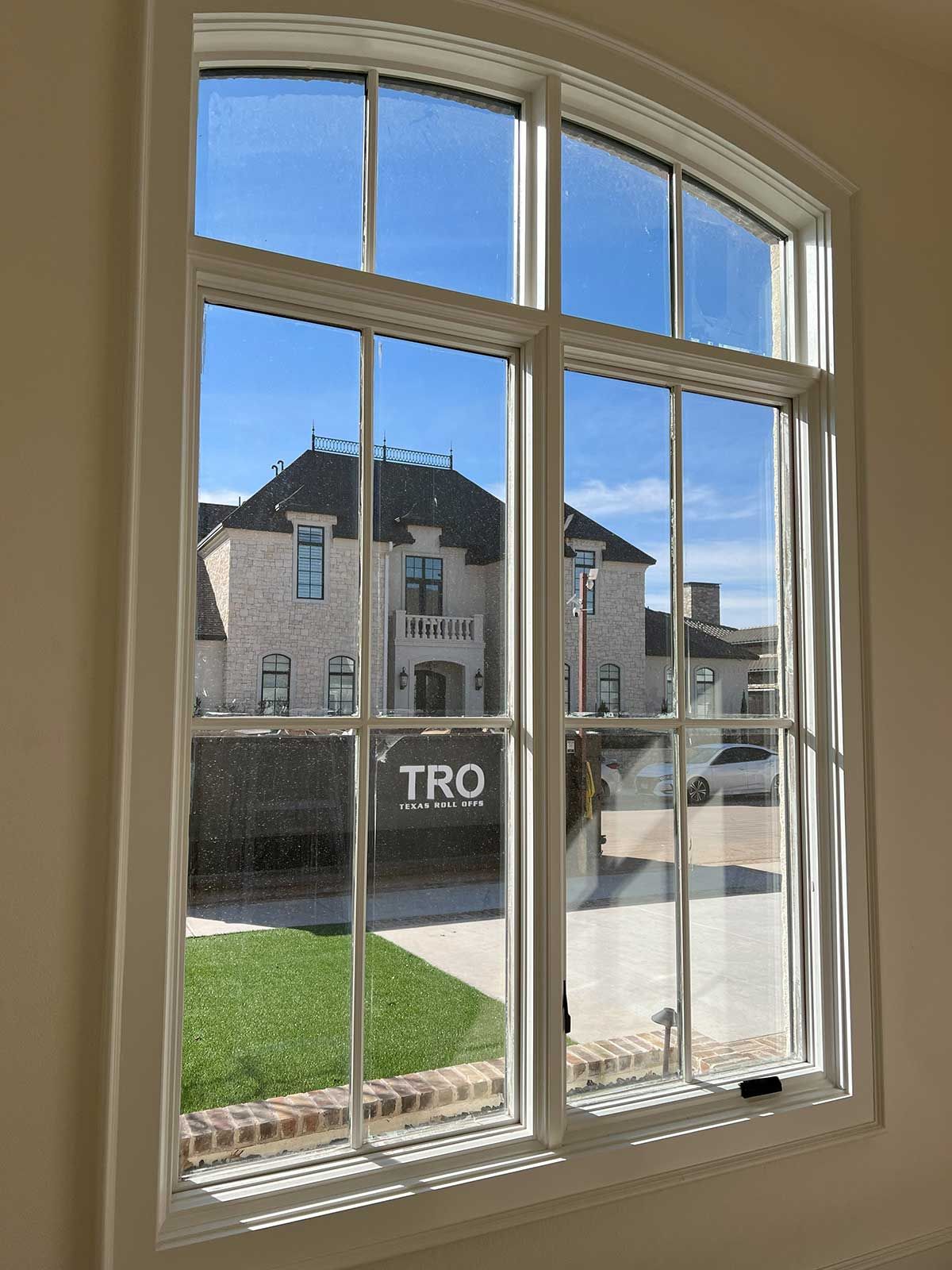 A large window with a view of a house and a sign that says tro