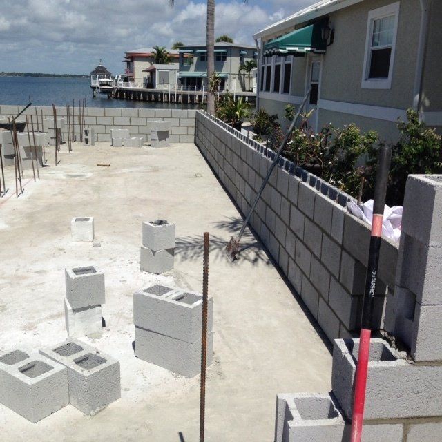 A brick wall is being built in front of a house