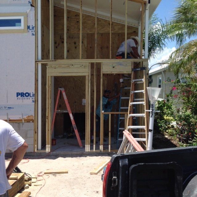 A truck is parked in front of a house that is being built