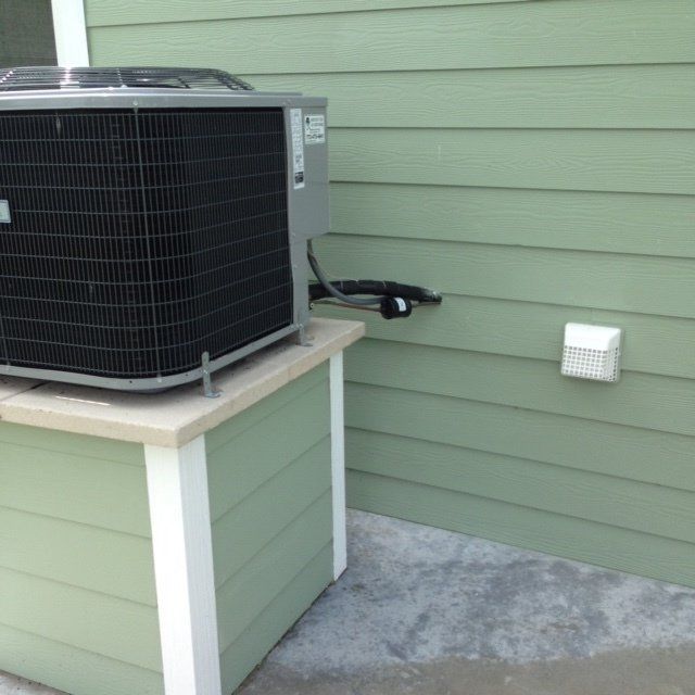 An air conditioner is sitting on top of a green box