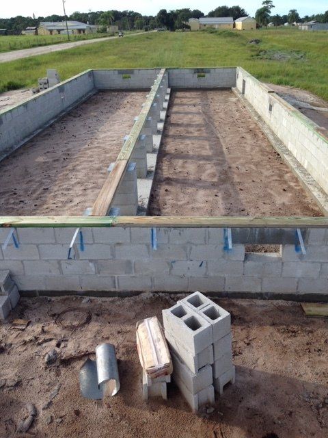 A brick wall is being built in a field