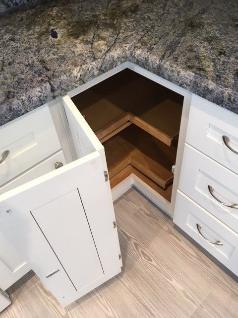 A kitchen with white cabinets and granite counter tops