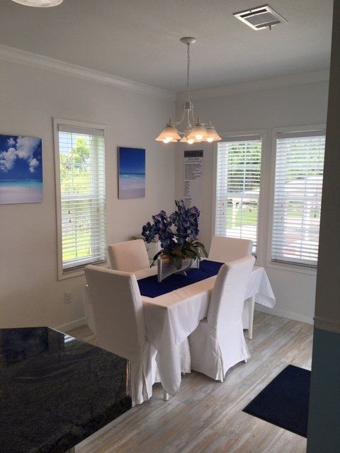 A dining room with a table and chairs and a blue table runner