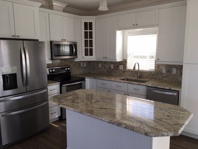 A kitchen with stainless steel appliances and granite counter tops.