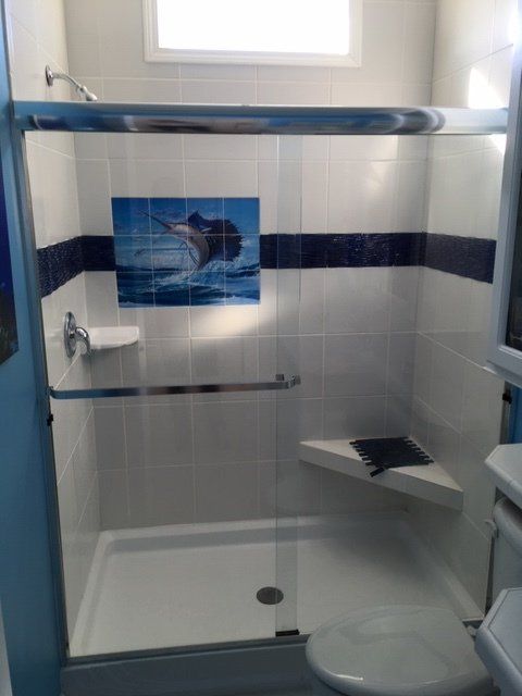 A bathroom with a shower and a picture of a dolphin on the wall