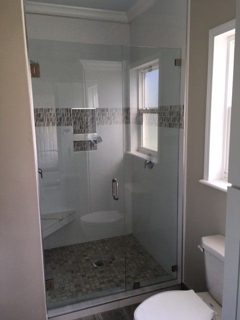 A bathroom with a toilet and a shower with a glass door