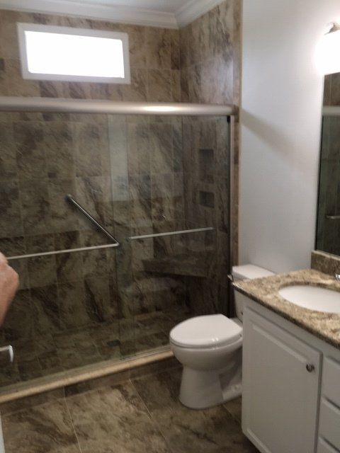 A bathroom with a toilet a sink and a walk in shower