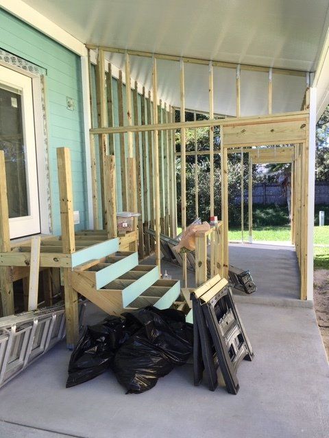 A wooden staircase is being built on the side of a house