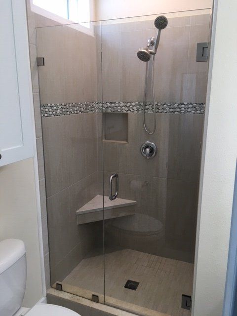 A bathroom with a toilet and a shower with a glass door