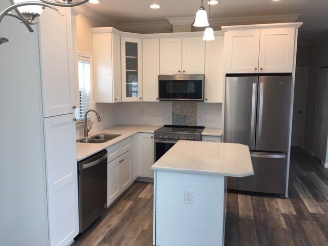 A kitchen with white cabinets and stainless steel appliances