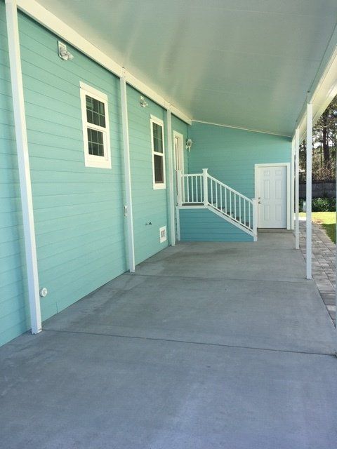 A blue house with a covered porch and stairs