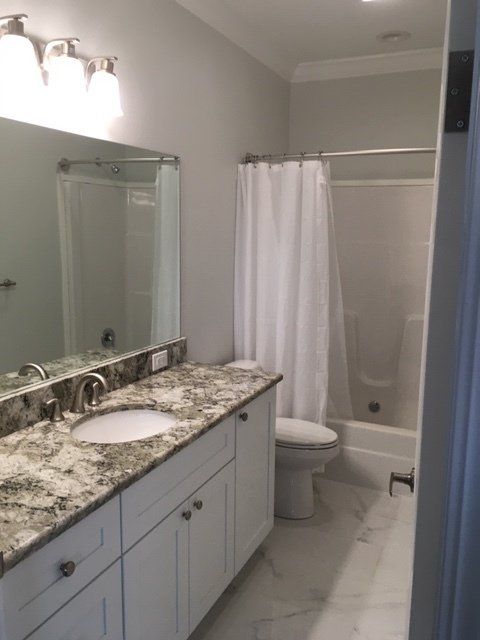 A bathroom with a sink a toilet and a shower