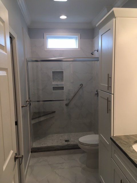 A bathroom with a walk in shower and a toilet