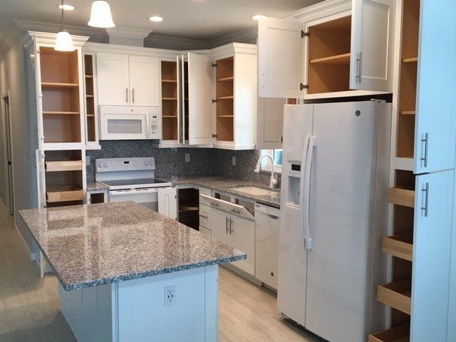 A kitchen with white cabinets and granite counter tops
