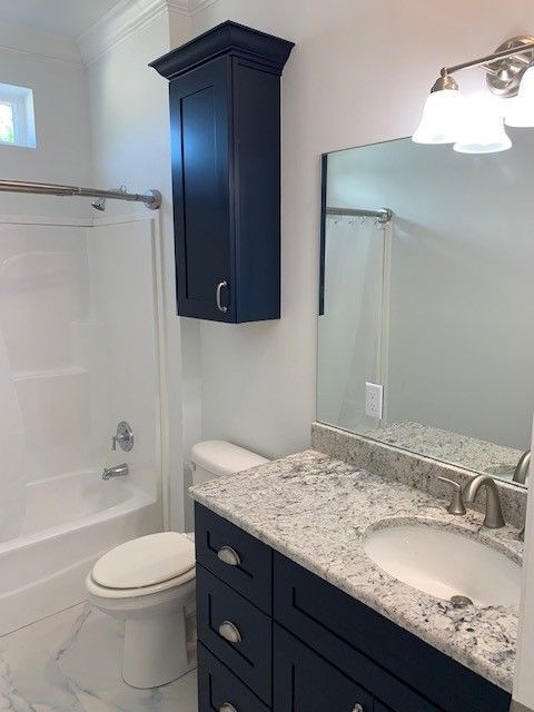 A bathroom with a toilet , sink , and mirror.