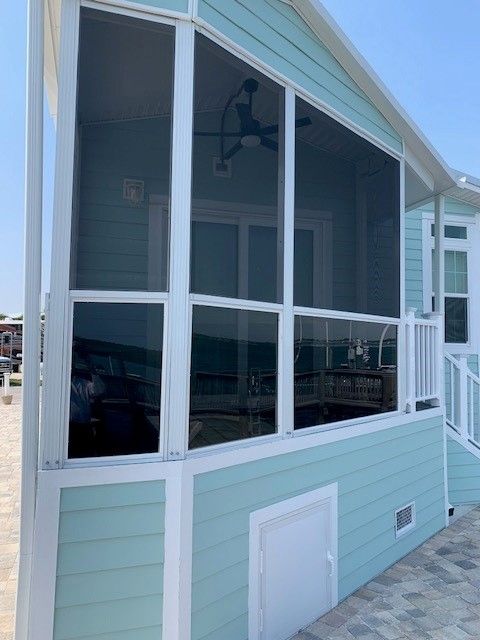 A house with a screened in porch and a ceiling fan.