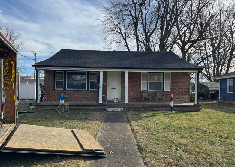 Single-story brick house with a front walkway, lawn, and a ramp leading to the porch