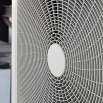 Close-up of a grey air conditioning unit fan, circular pattern.