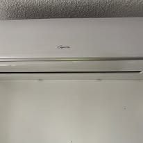 White air conditioner on a white wall;