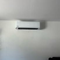 White wall-mounted air conditioner on a plain white wall.