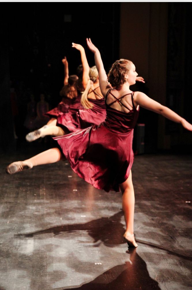 Three Ballet Dancers in red dress spinning in a circle 