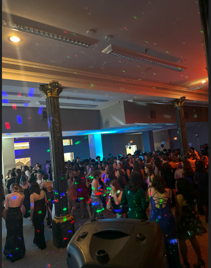 A large group of people are dancing in a large room