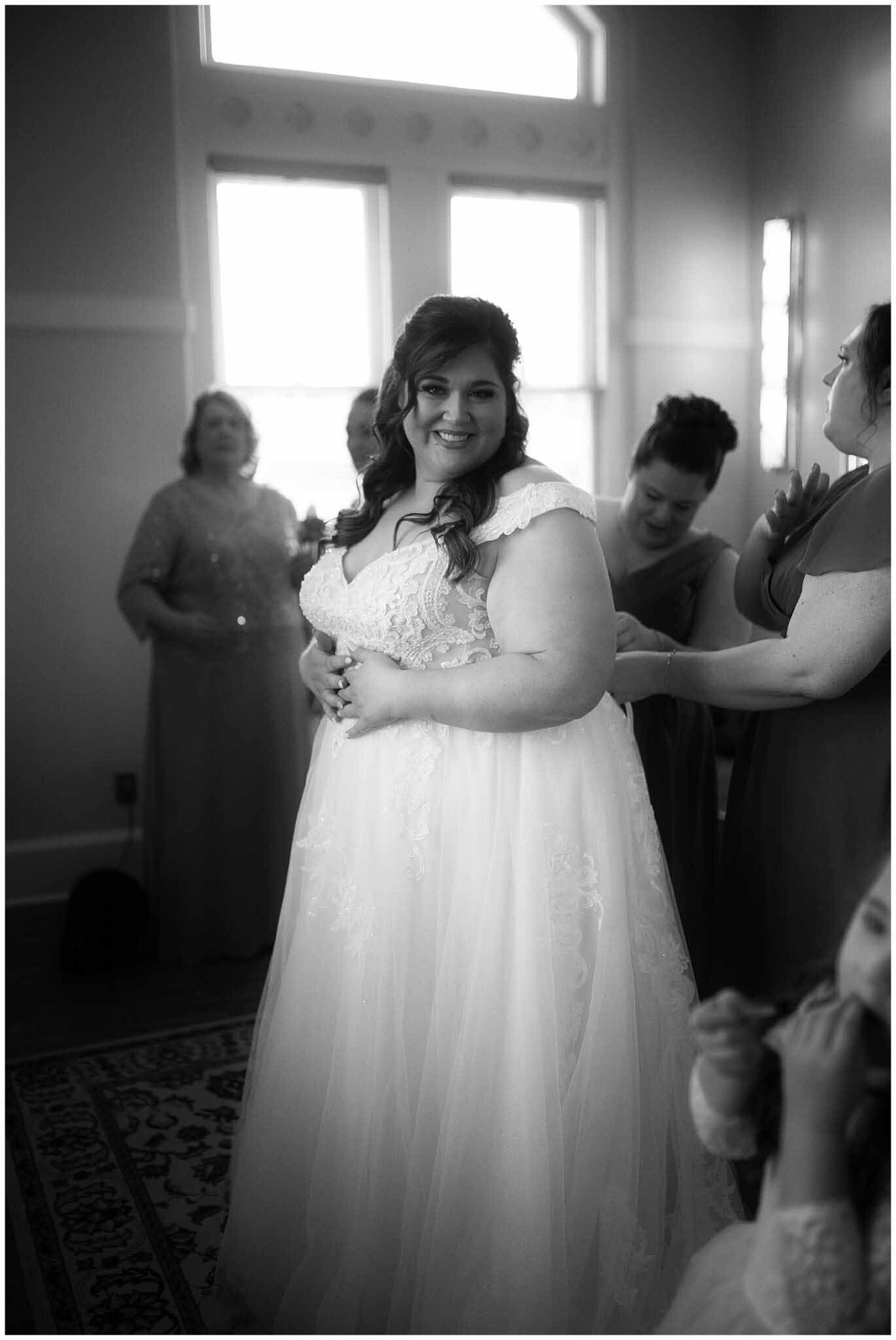 A black and white photo of a bride getting ready for her wedding.