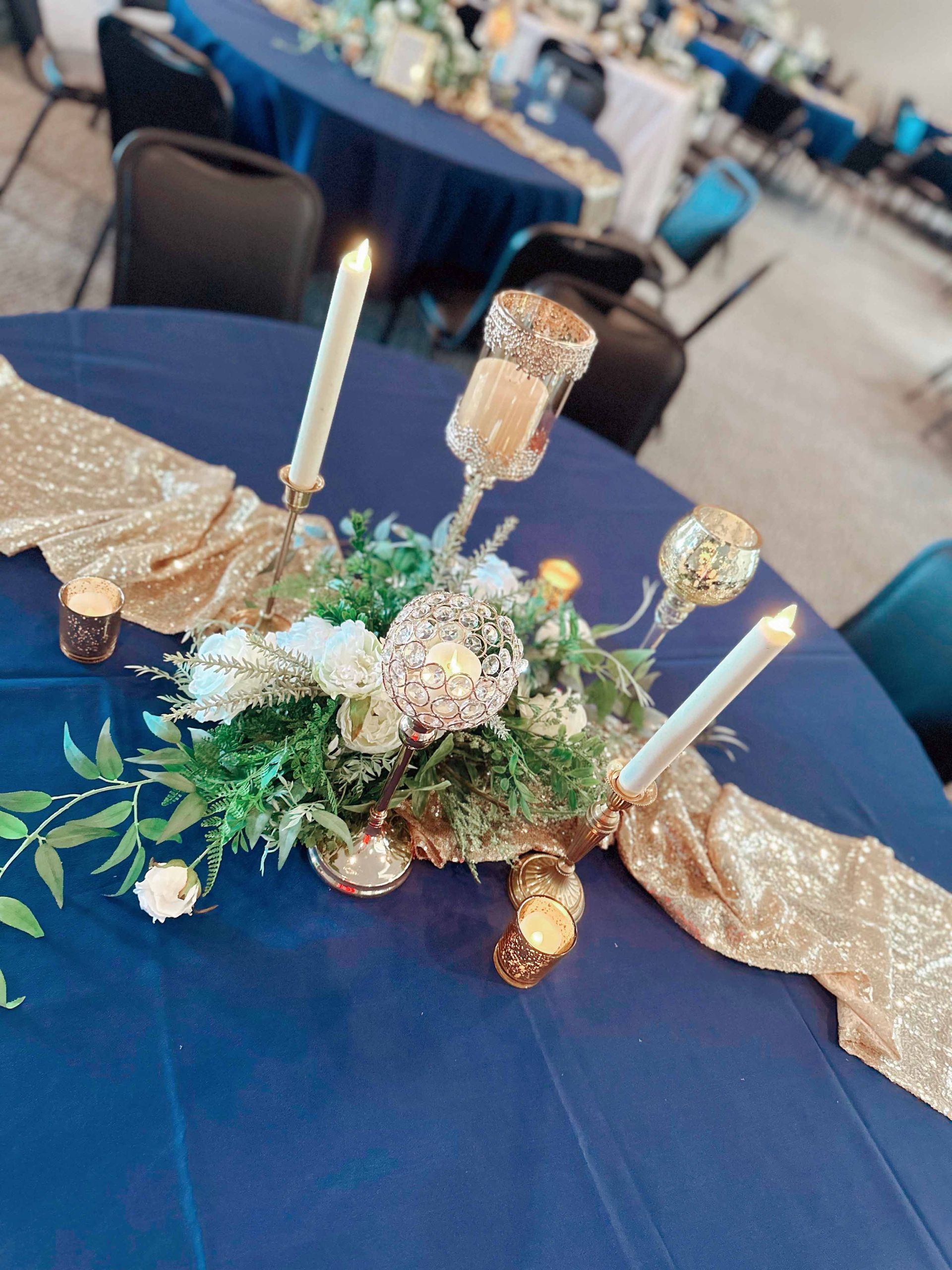 A table with a vase of flowers and candles on it.