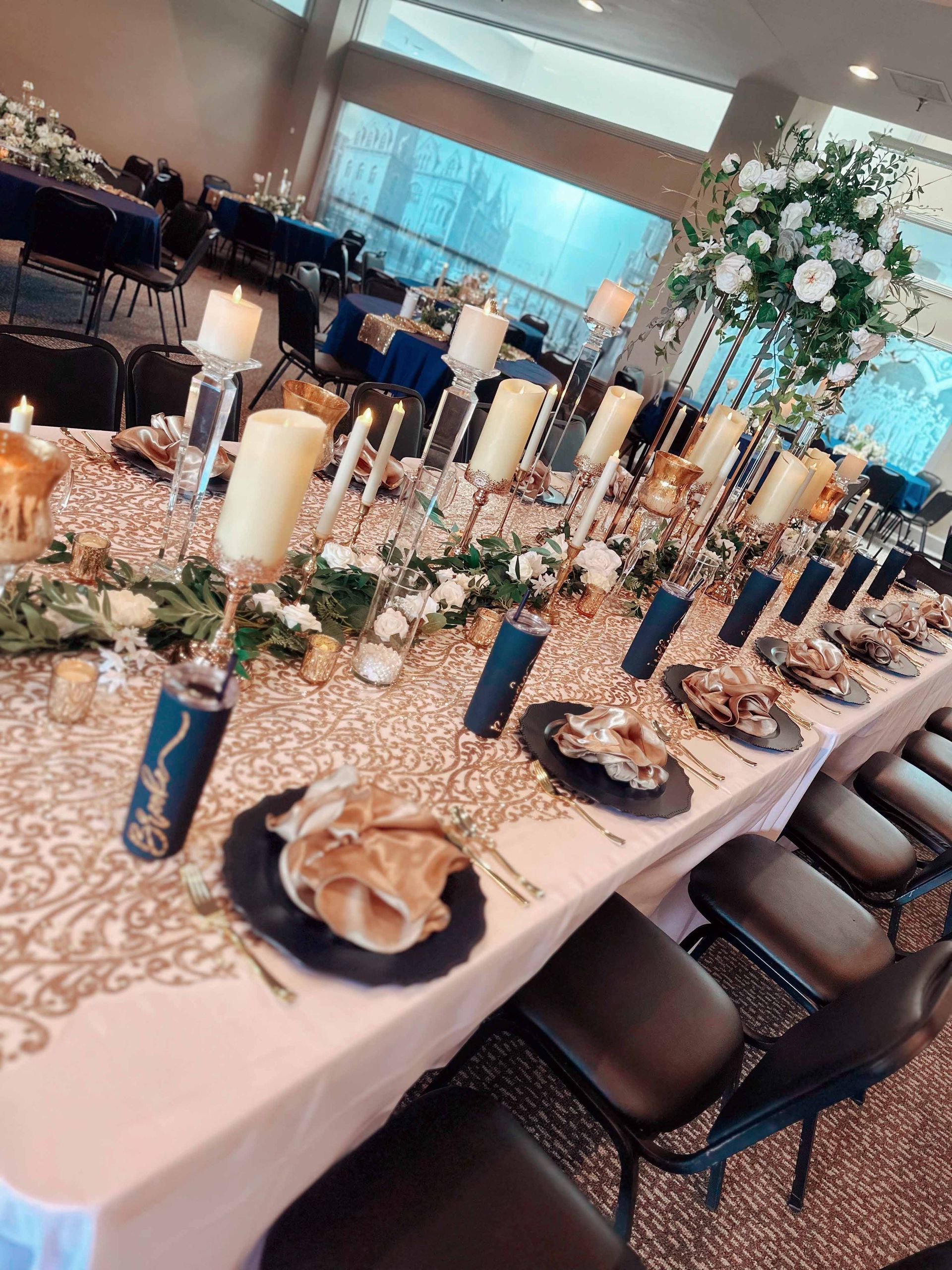 A long table with plates , candles , and flowers on it.