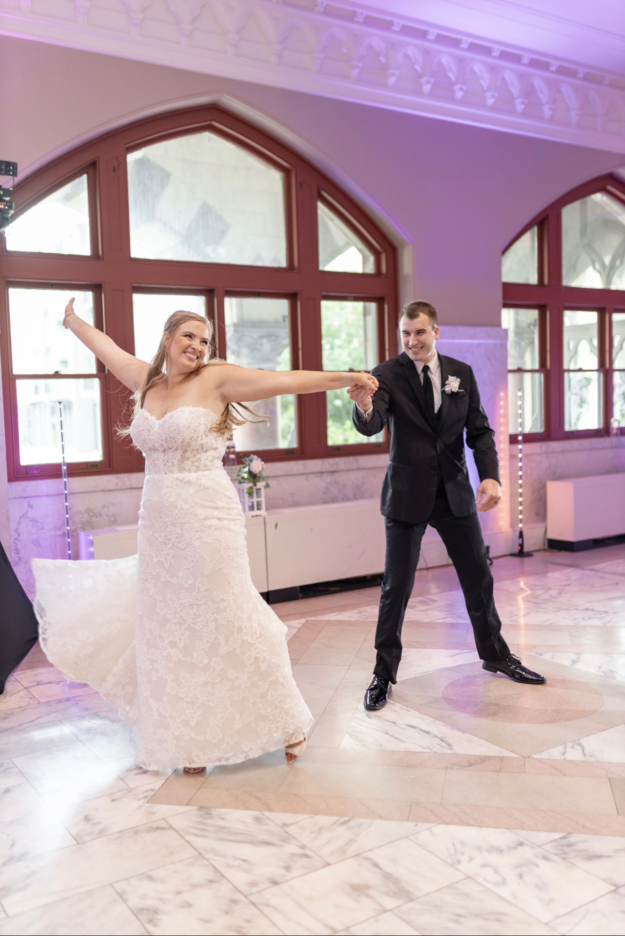 A bride and groom are dancing together at their wedding reception.
